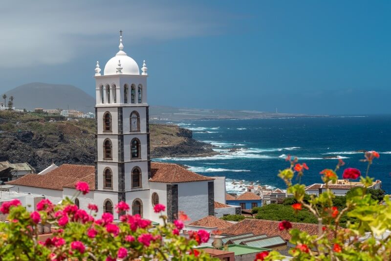 Church of Santa Ana in Garachico with views of the Atlantic Ocean and colourful coastal houses.